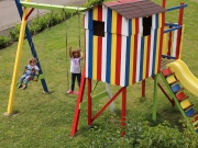 Land-und-Kind.de Spielhaus, gestrichen mit Alpina Farben: Komplettansicht mit Schaukel