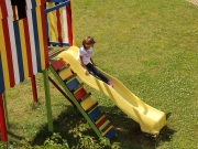 Land-und-Kind.de Spielhaus, gestrichen mit Alpina Farben: Mädchen auf der Rutsche
