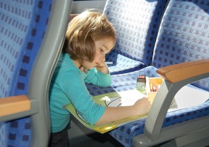 Kind im Zug mit Reiselektüre. Copyright: Deutsche Bahn AG