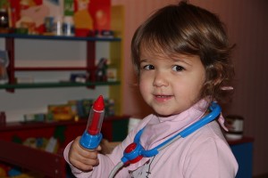 Kleines Mädchen spielt Ärztin, Stethoskop, Spritze