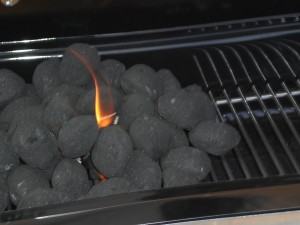 Grillkohle auf einem Grillrost mit kleiner Flamme