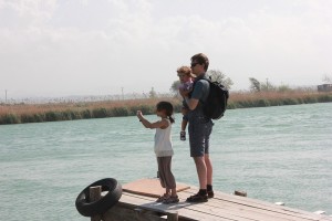 Familie im Urlaub - Vater und Töchter genießen den Ausblick auf einen Fluss