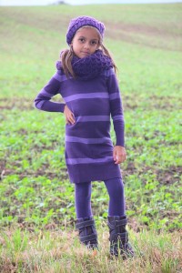 Mädchen in Herbstkombi: Kleid, Stiefel, Schal und Mütze